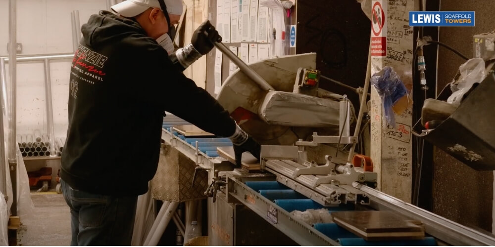 the metal man cutting excess wood off toe-board
